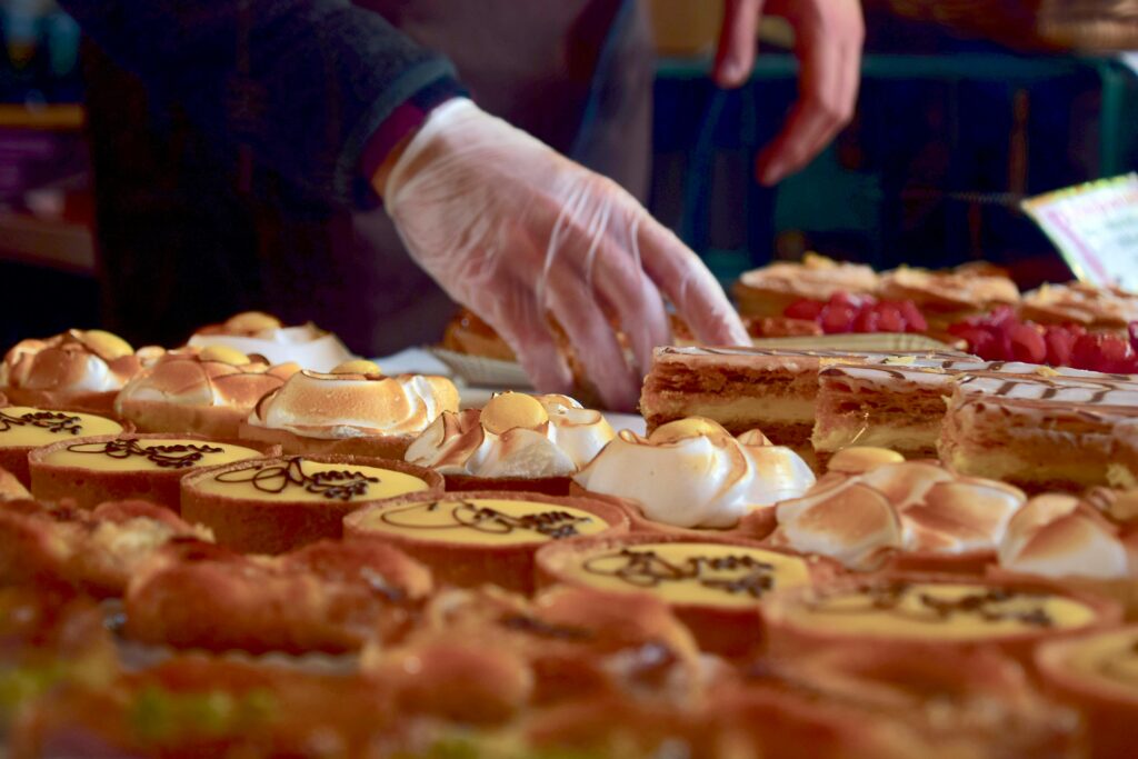 Delicious assorted pastries including custard slices and meringues at a London market stall.